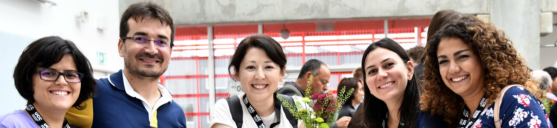 Young peole at a social event looking at the photographer, smiling. 