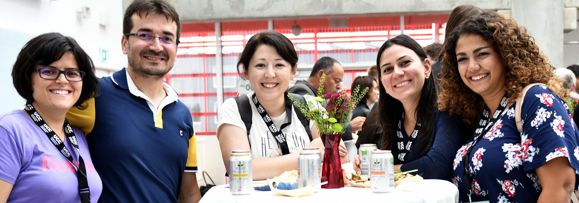 Young peole at a social event looking at the photographer, smiling. 